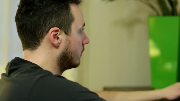 Молодой человек играет в видеоигры на персональном компьютере — стоковое видео