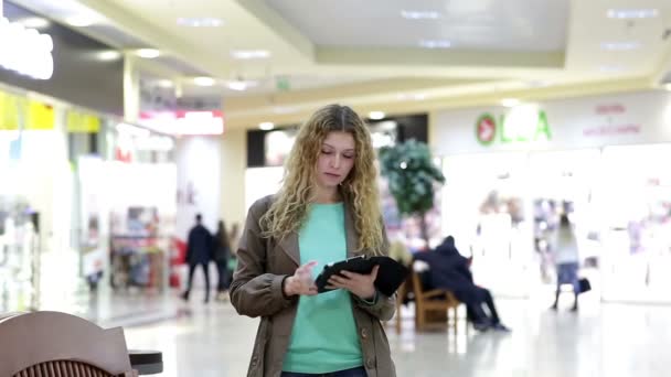 Młoda kobieta z tabletka poznaje faceta w centrum handlowym — Wideo stockowe