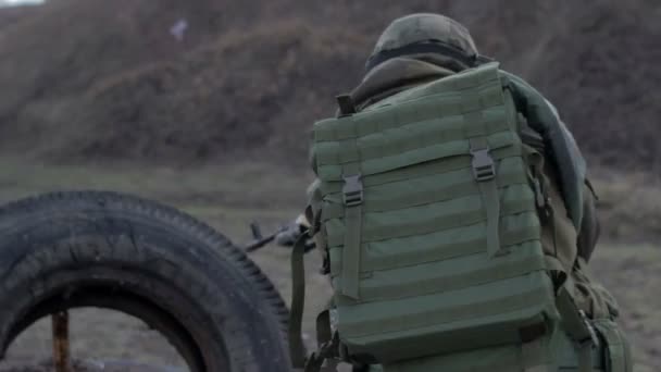 En soldat med en kulspruta på ett militärt skjutfält skytte på måltavla. — Stockvideo
