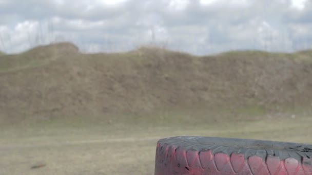 Een soldaat met een machinegeweer op een militaire schietbaan schieten op een doel. — Stockvideo