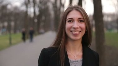 Genç güzel kız siyah şapkalı gülümseyerek mutlu bir şekilde kameraya, ağır çekim, kapatın.