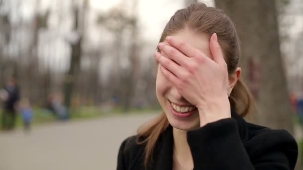 Young pretty girl smiles happily into camera, close up, slow motion — Stock Video