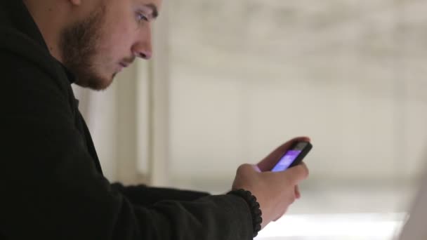 Young man with a smartphone on the covered bridge. — Stock Video