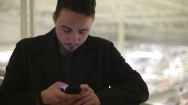 Kapalı köprüde bir akıllı telefon ile genç adam.