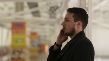 Kapalı köprüde bir akıllı telefon ile genç adam.