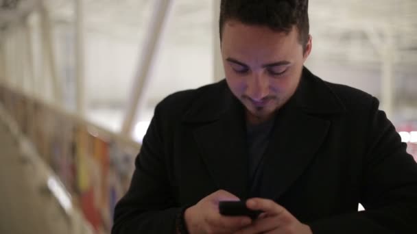 Joven con un smartphone en el puente cubierto . — Vídeos de Stock