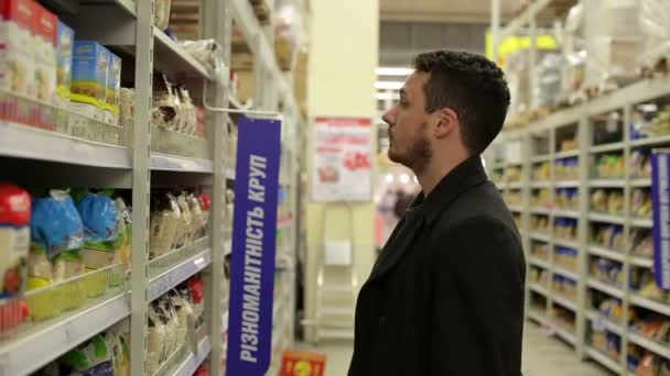 Mann wählt Produkte im Supermarkt — Stockvideo