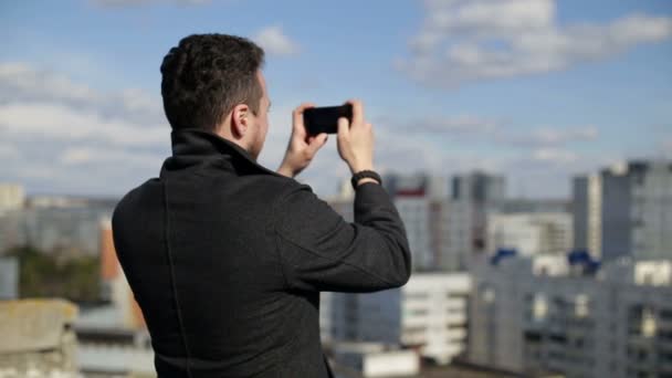 Ένας άντρας παίρνει φωτογραφίες στη στέγη. — Αρχείο Βίντεο