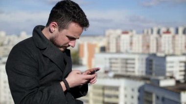 Hareket eden telefon ve sms bir evin çatısında yazma adam