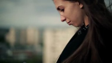 Genç kadın bir smartphone çatıda kullanır.