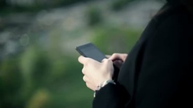 Genç kadın bir smartphone çatıda kullanır.