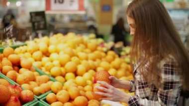 Genç kadın ürünleri süpermarkette seçer.