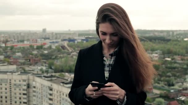 Junge Frau nutzt Smartphone auf dem Dach — Stockvideo