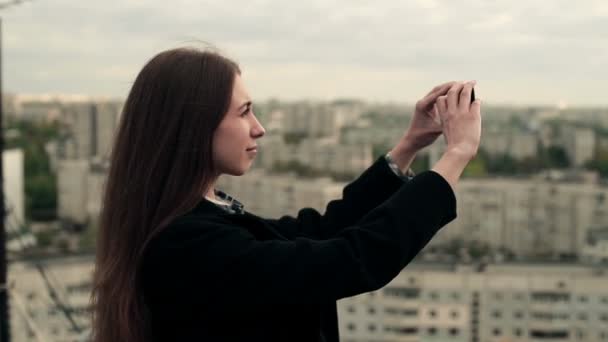 Νεαρή γυναίκα χρησιμοποιεί ένα smartphone στην οροφή — Αρχείο Βίντεο