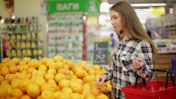 Молодая женщина выбирает продукты в супермаркете — стоковое видео