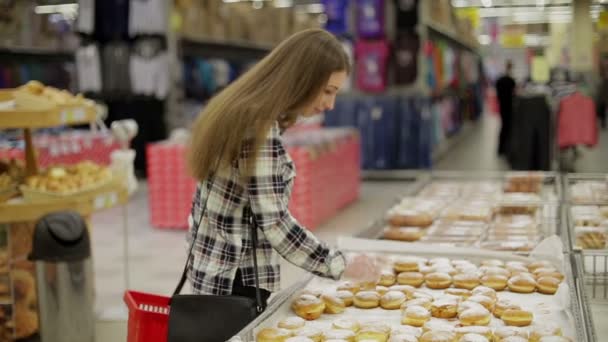 Ung kvinna väljer produkter i snabbköpet — Stockvideo