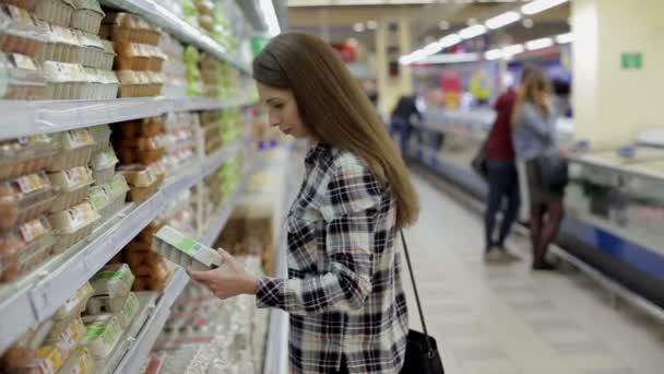 Fiatal nő választja ki a termékeket a szupermarketben