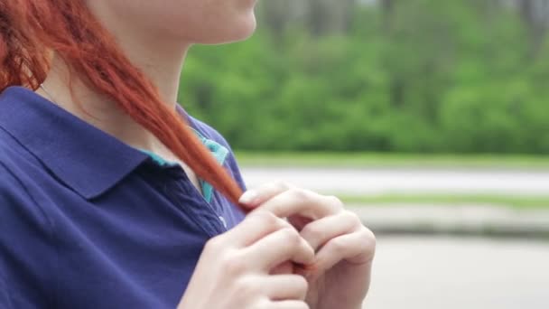 Roodharige meisje permanent alleen in het midden van een straat, kam haar haar en glimlachen — Stockvideo