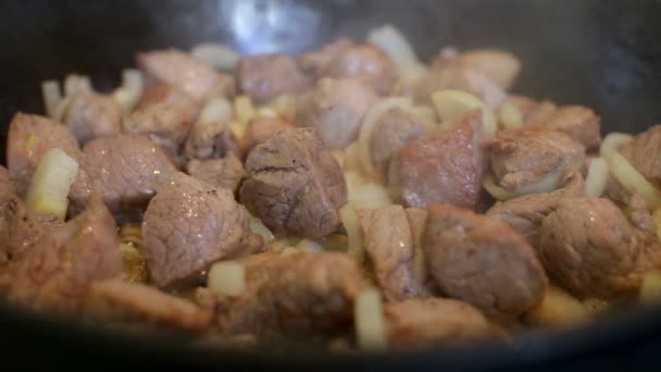Шеф-повар готовит лук и мясо на сковородке — стоковое видео