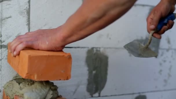 Work lays bricks on a construction site — Stock Video