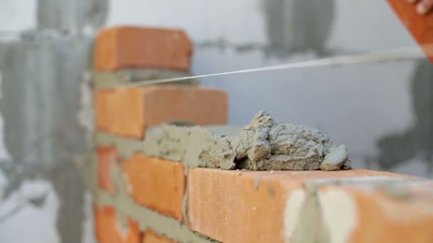 Arbeit legt Ziegel auf einer Baustelle — Stockvideo