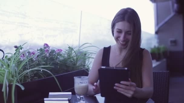 Young attractive woman using laptop while sitting in cafe — Stock Video