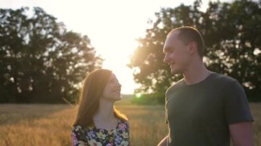 Birkaç kucaklama, öpücük ve gün batımında geniş açık bir altın alandaki sonra yürüyüş