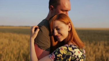 Birkaç kucaklama, öpücük ve gün batımında geniş açık bir altın alandaki sonra yürüyüş