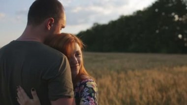 Birkaç kucaklama, öpücük ve gün batımında geniş açık bir altın alandaki sonra yürüyüş