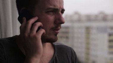 Cep telefonuyla konuşurken ve etrafa genç adam