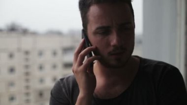 Cep telefonuyla konuşurken ve etrafa genç adam