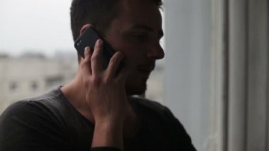 Cep telefonuyla konuşurken ve etrafa genç adam