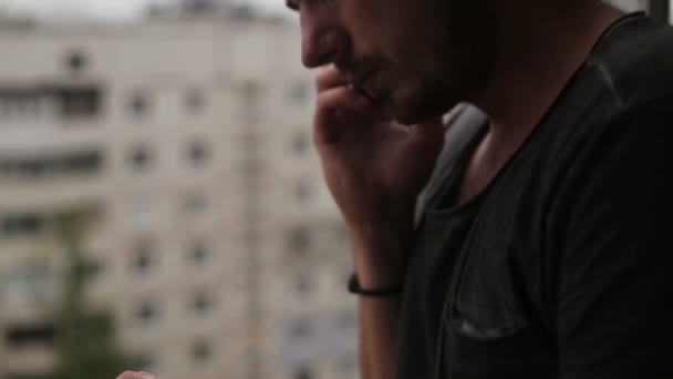 Mladý muž mluví na mobilním telefonu a rozhlédl se kolem sebe — Stock video