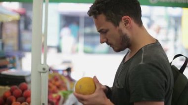 Adam bir kavun yemek piyasada satın alır.