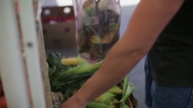 Adam bir sebze pazarı, Mısır gün alıyor.