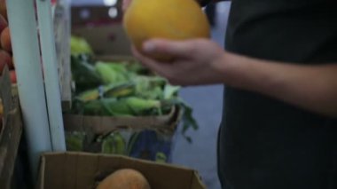 Adam bir kavun yemek piyasada satın alır.