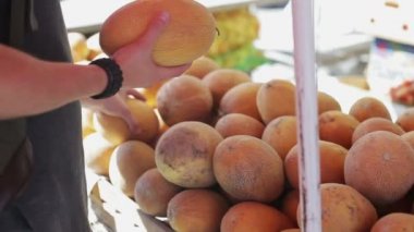 Adam bir kavun yemek piyasada satın alır.