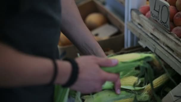 Homem compra milho em um mercado de vegetais no dia — Vídeo de Stock