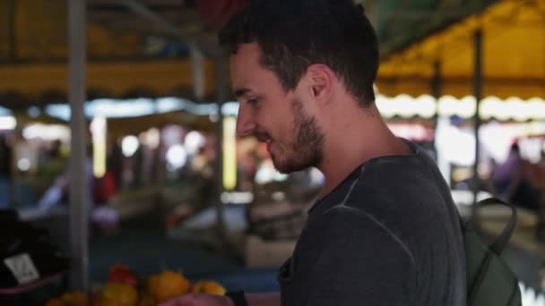 Ein Mann kauft Gemüse am Tag auf einem Markt — Stockvideo