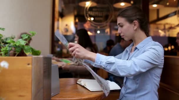 Fiatal gyönyörű nő azt írja, a kávézó, és úgy néz ki, Térkép — Stock videók