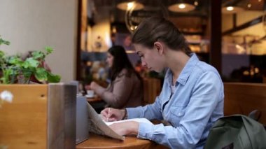 Genç güzel kadın café'de yazıyor ve Haritaya benziyor