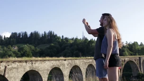 Feliz casal romântico turistas na frente da ponte velha fazer foto — Vídeo de Stock