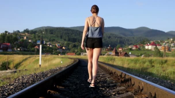 Kobieta spaceru na kolej w górach — Wideo stockowe