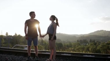 Yürüyüş ve huging birlikte dağlarda eski demiryolu üzerinde genç Çift