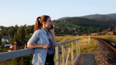 Gülümseyen güzel genç kadın ile smartphone dağlarda