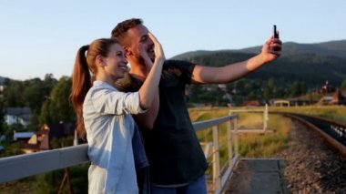 Dağlarda smartphone ile fotoğraf çekmek güzel genç çift gülümseyen