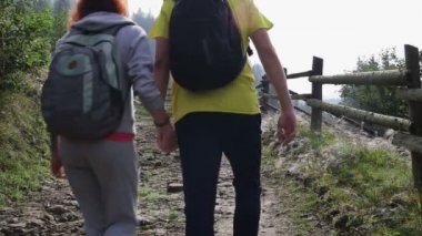 Çift Backpackers dağlarda yolda yürüyüş