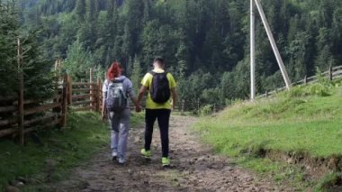 Çift Backpackers dağlarda yolda yürüyüş