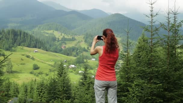 Das Mädchen in den Bergen macht das Foto am Telefon — Stockvideo