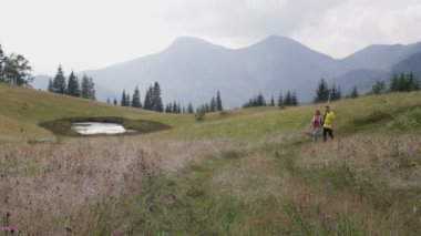 Çift Backpackers dağlarda yolda yürüyüş